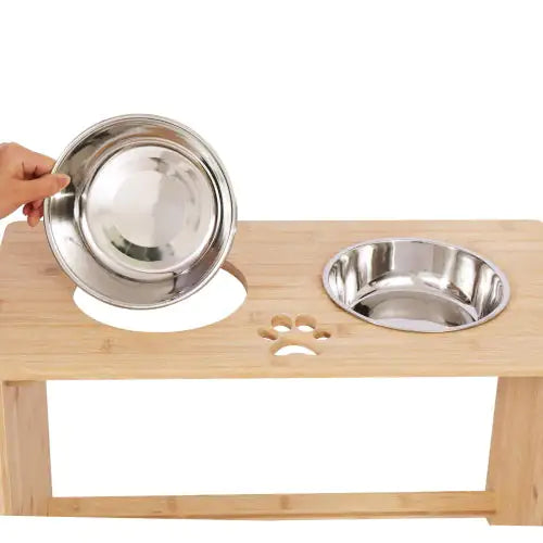 Pet feeding station with two stainless steel bowls on a wooden stand.